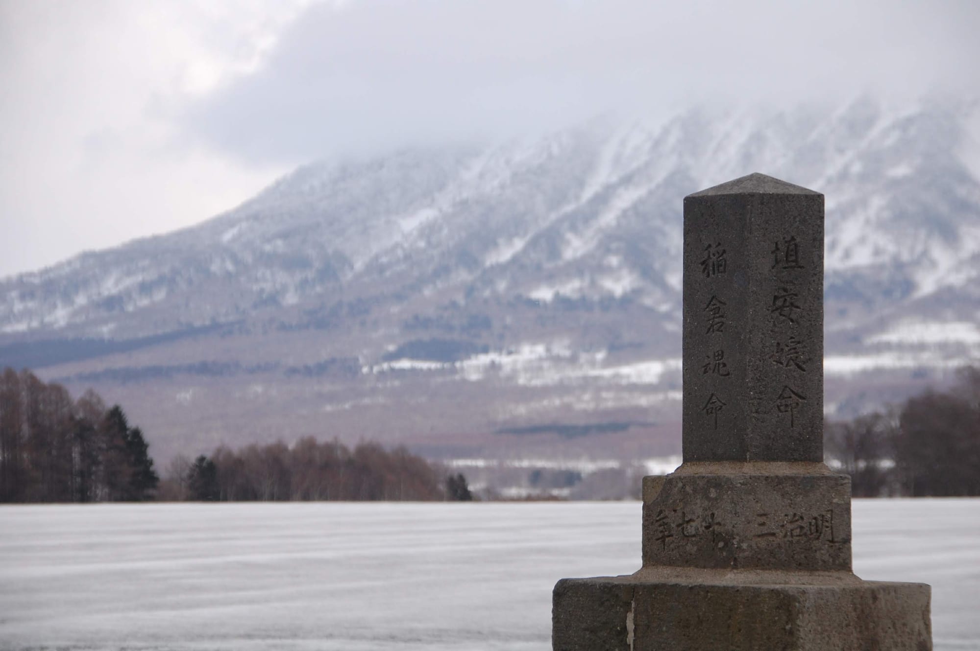 A stone monument with a mountain in the background