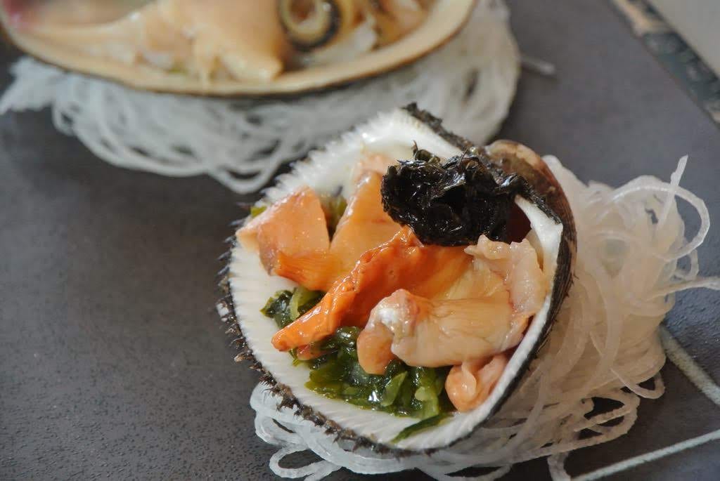 Abalone served in its shell over shredded daikon